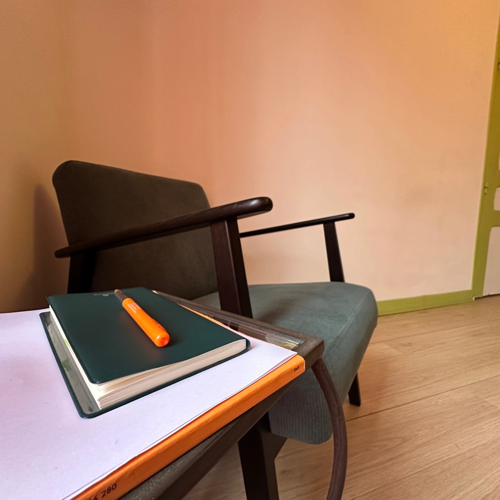 Coin lecture du cabinet, fauteuil et carnets posés